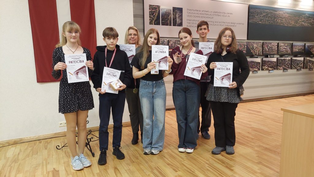 Skolēni un skolotāja ar Diplomiem un Pateicības rakstiem